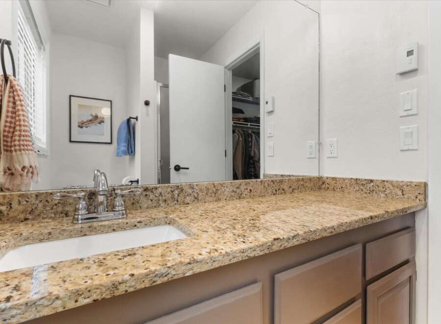 This bathroom boasts a stunning granite countertop and a modern sink, creating a luxurious and functional space.