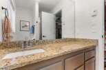 This bathroom boasts a stunning granite countertop and a modern sink, creating a luxurious and functional space.
