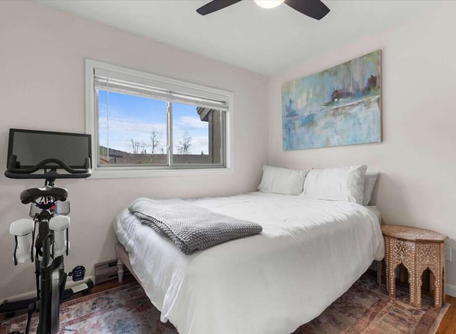 This cozy bedroom offers a serene retreat with its bright, airy ambiance and stylish decor.