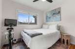 This cozy bedroom offers a serene retreat with its bright, airy ambiance and stylish decor.