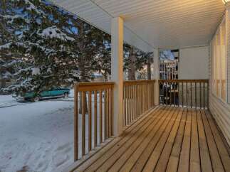 Step into a cozy retreat with this charming porch, perfect for enjoying the serene winter landscape.