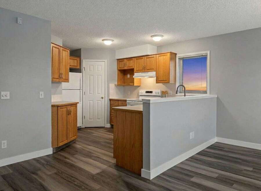 Step into this inviting kitchen, featuring warm wooden cabinetry and sleek countertops.