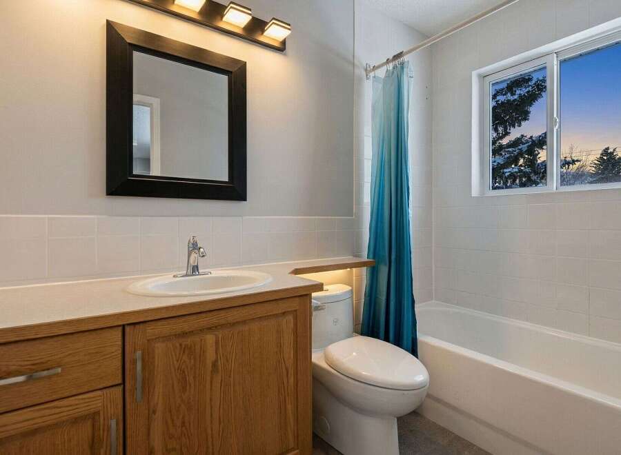 This inviting bathroom features a modern design with a sleek vanity and a stylish mirror.