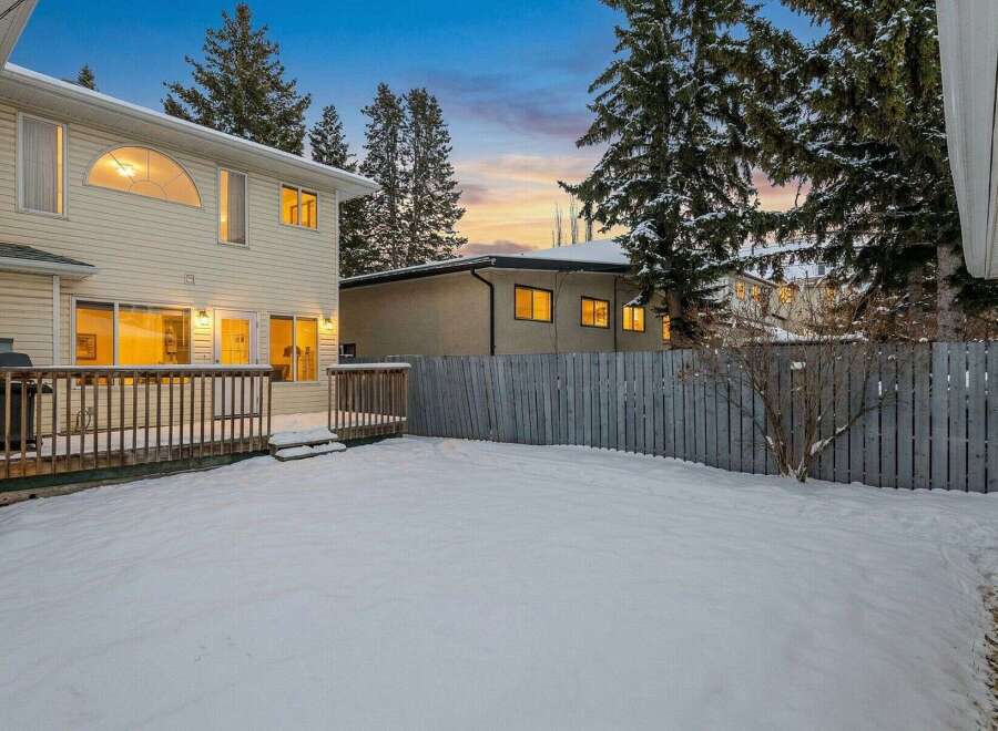 Discover this charming property featuring a spacious backyard blanketed in fresh snow, perfect for winter activities.