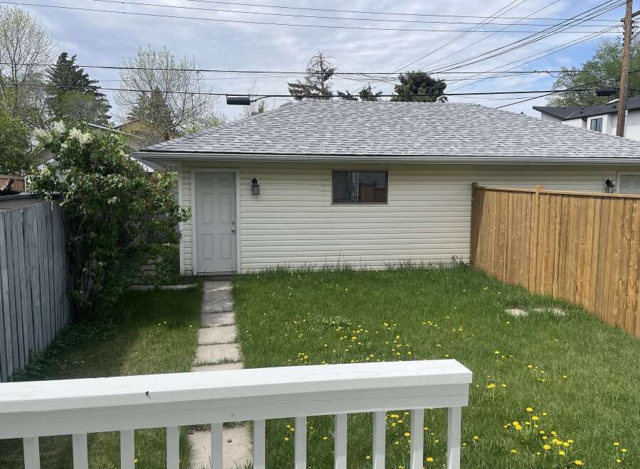 This charming property features a detached garage with a neutral color scheme and a well-maintained roof.