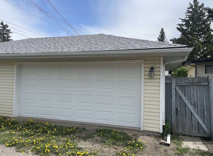 This charming property boasts a detached garage with a classic white garage door, offering convenient parking and storage solutions.