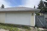 This charming property boasts a detached garage with a classic white garage door, offering convenient parking and storage solutions.