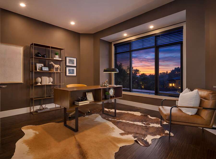 Step into luxury with this stunning home office, featuring a modern desk and a cozy leather armchair.
