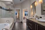 Step into luxury with this stunning bathroom featuring a sleek glass shower, a relaxing bathtub, and elegant double sinks.