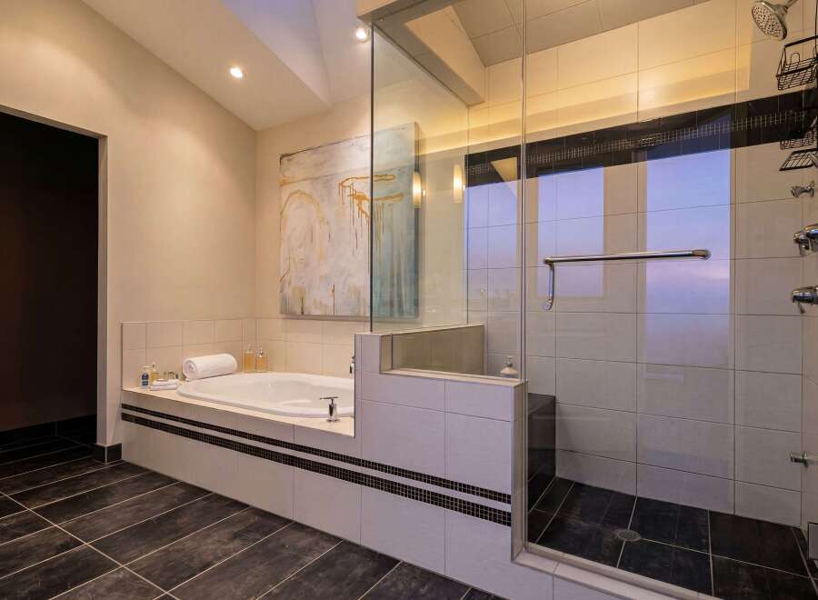 Step into luxury with this stunning bathroom featuring a sleek glass-enclosed shower and a relaxing soaking tub.