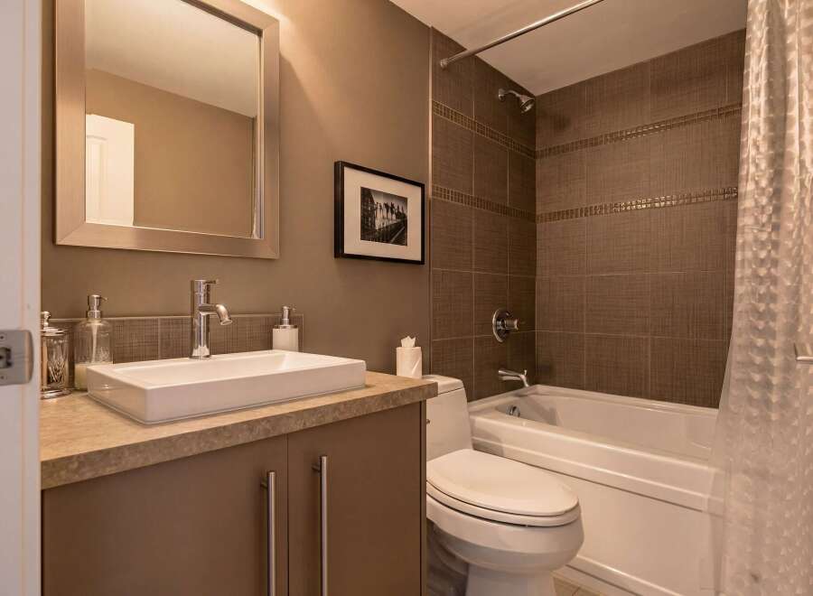 Step into this modern bathroom, featuring a sleek vanity with a rectangular sink and ample storage.