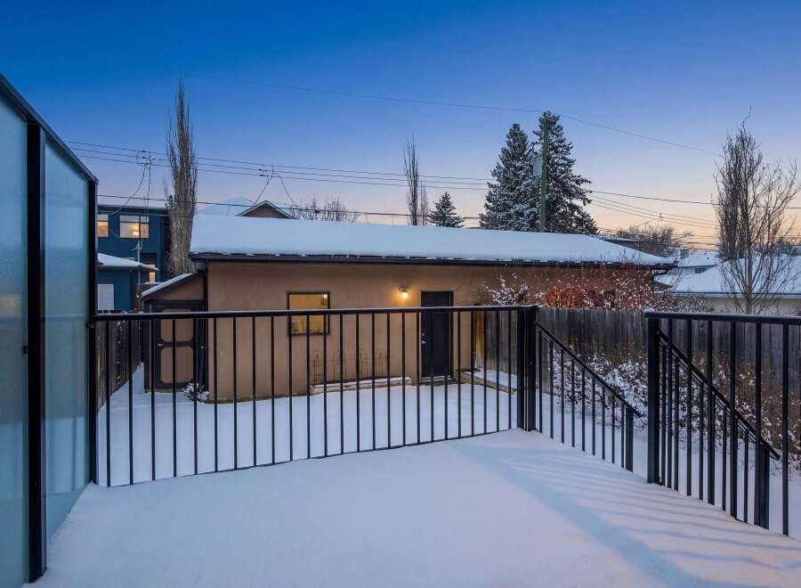 Enjoy the serene beauty of this property, featuring a snow-covered deck and a charming exterior.