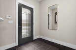 Step into this inviting entryway, showcasing a modern front door with a glass panel design.