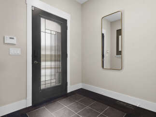 Step into this inviting entryway, showcasing a modern front door with a glass panel design.