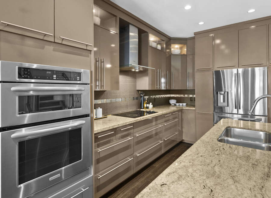 This modern kitchen boasts sleek, high-gloss cabinetry and stainless steel appliances, creating a sophisticated and functional space.