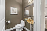This stunning powder room showcases a modern design with a unique vessel sink and elegant fixtures.