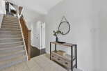 Step into this inviting entryway, showcasing a stunning staircase with carpeted steps and a warm wooden banister.