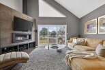 Step into luxury with this stunning living room, featuring a modern fireplace and a sleek entertainment center.