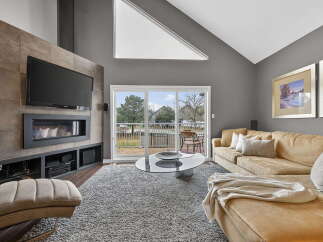Step into luxury with this stunning living room, featuring a modern fireplace and a sleek entertainment center.