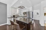 This stunning kitchen boasts a modern design with sleek white cabinetry and a contrasting dark island.