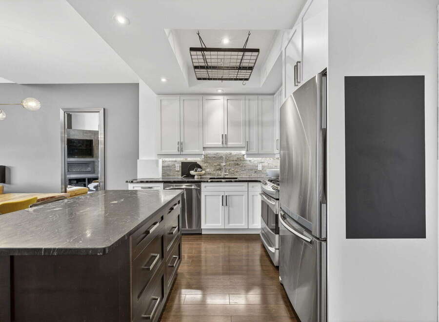This stunning kitchen boasts a modern design with sleek stainless steel appliances and a spacious island.