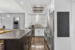 This stunning kitchen boasts a modern design with sleek stainless steel appliances and a spacious island.