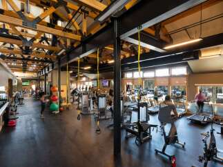 This stunning fitness center boasts a spacious layout with high ceilings and ample natural light, creating an inviting atmosphere for workouts.