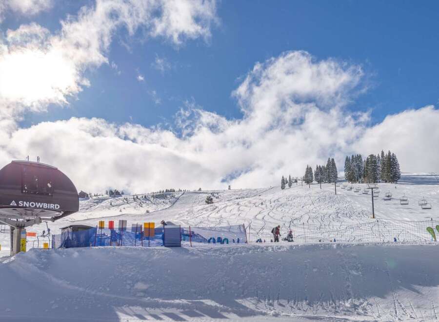 Enjoy the winter wonderland at this stunning ski resort! This property boasts breathtaking views of snow-covered slopes and a vibrant blue sky.