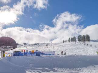 Enjoy the winter wonderland at this stunning ski resort! This property boasts breathtaking views of snow-covered slopes and a vibrant blue sky.