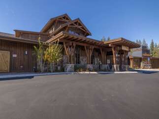 This stunning property boasts a rustic design with wooden accents and stone pillars, creating a warm and inviting atmosphere.