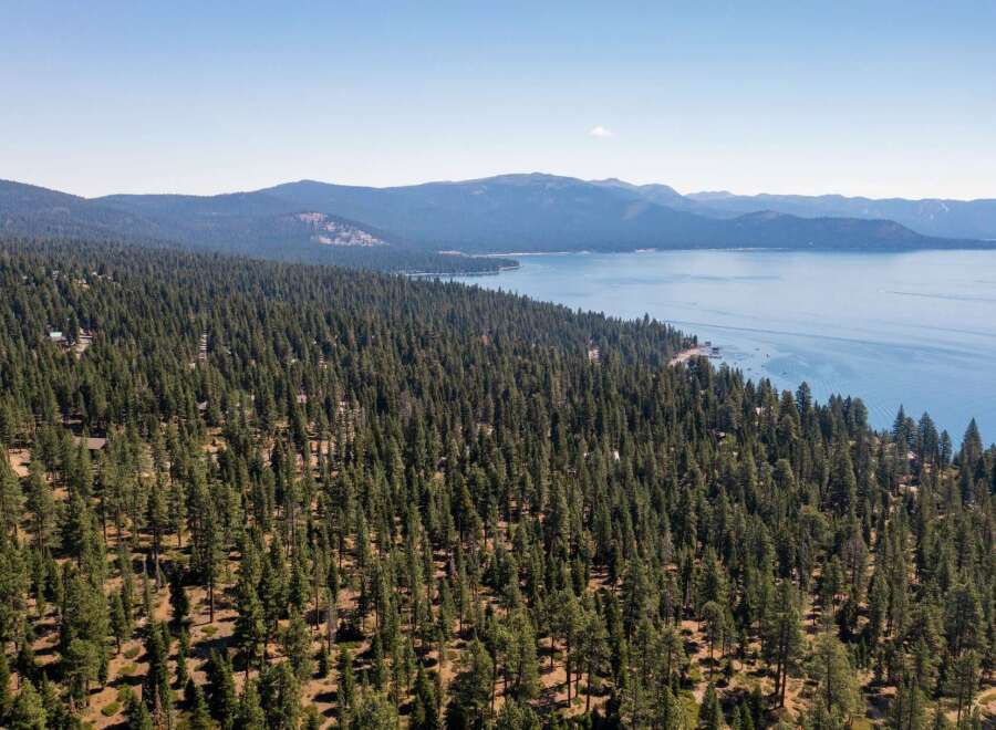 Discover the tranquility of this stunning property, nestled amidst a lush forest and offering breathtaking views of the serene lake.