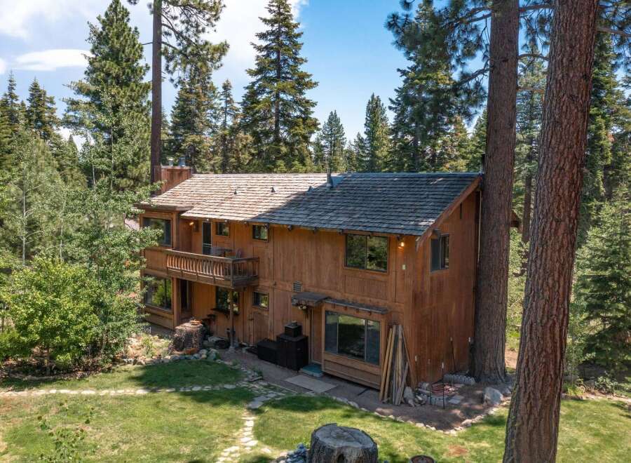 Nestled amidst towering trees, this stunning wooden cabin offers a serene escape.
