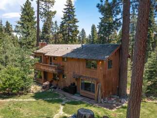 Nestled amidst towering trees, this stunning wooden cabin offers a serene escape.