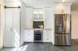 This stunning kitchen boasts a modern design with sleek white cabinetry and elegant copper hardware.