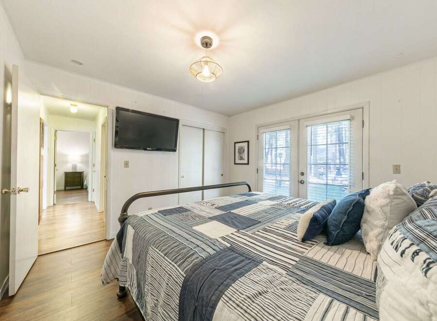 Step into this inviting bedroom, featuring a cozy bed adorned with a stylish quilt and plush pillows.