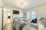 Step into this inviting bedroom, featuring a cozy bed adorned with a stylish quilt and plush pillows.