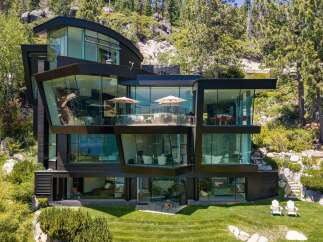 Experience modern luxury in this stunning multi-level home, featuring expansive glass walls that offer breathtaking views of the surrounding natural landscape.