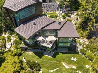 Experience modern luxury in this stunning architectural home, featuring expansive glass walls and a unique, angular design that seamlessly integrates with the natural landscape.