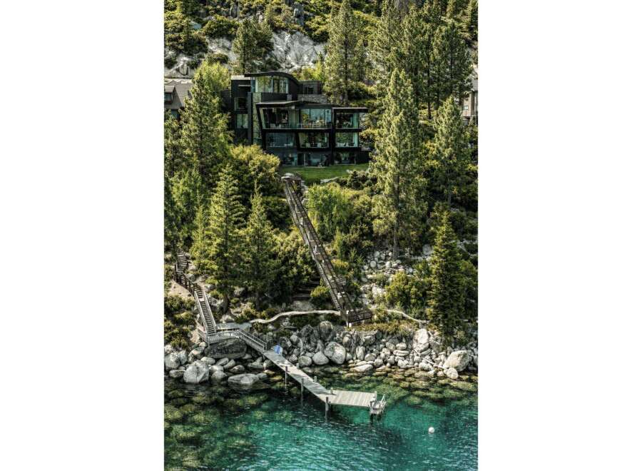 Experience luxury living with this stunning modern home nestled amidst lush trees and overlooking crystal-clear waters.