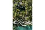 Experience luxury living with this stunning modern home nestled amidst lush trees and overlooking crystal-clear waters.