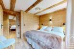 Experience the charm of this stunning property, featuring a cozy bedroom with wooden accents and a plush bed.