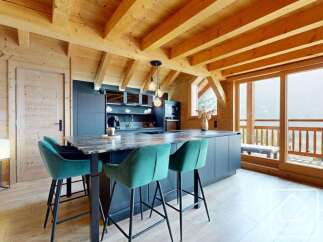 Experience luxury living in this stunning property, featuring a modern kitchen with sleek countertops and stylish bar stools.