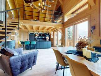 Experience luxury living in this stunning chalet, featuring a modern kitchen with sleek countertops and a cozy living area.