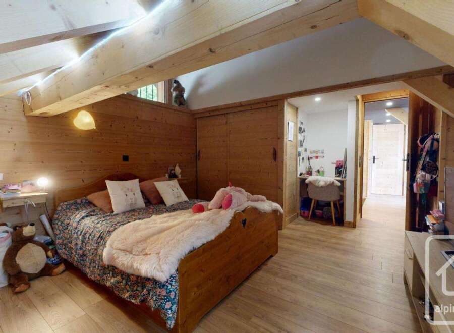 Discover the charm of this cozy bedroom, featuring a warm wooden interior and a comfortable bed.