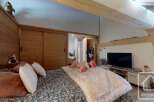 Discover the charm of this cozy bedroom, featuring rustic wooden accents and a comfortable bed.