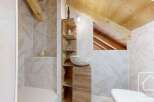 Discover the charm of this unique bathroom design, featuring a rustic wooden vanity and a stylish stone sink.