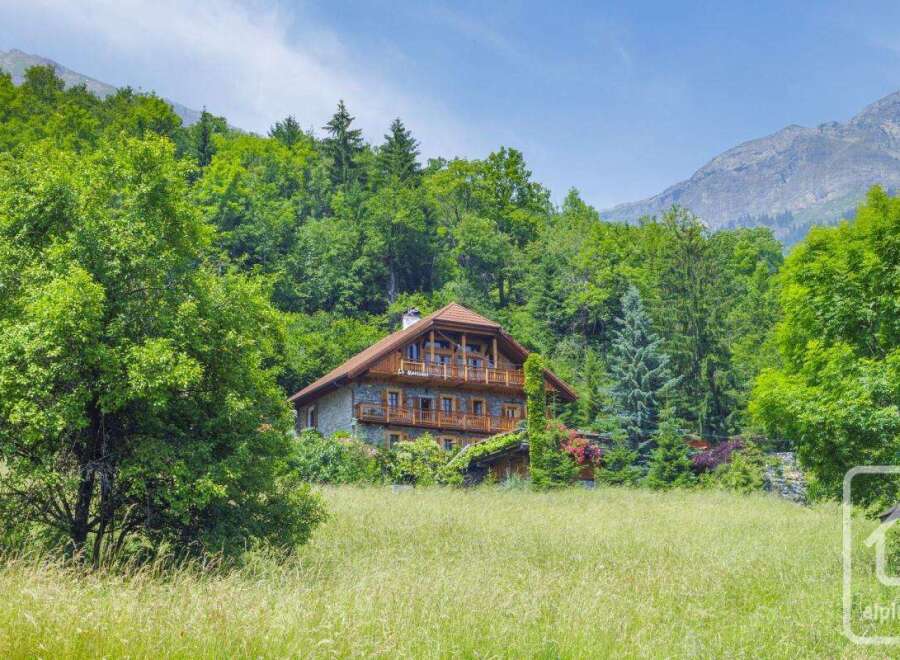 Discover your dream alpine retreat! This stunning property boasts a charming wooden facade, nestled amidst lush greenery and breathtaking mountain views.