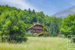 Discover your dream alpine retreat! This stunning property boasts a charming wooden facade, nestled amidst lush greenery and breathtaking mountain views.