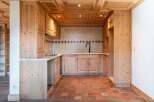 This charming kitchen features a rustic design with wooden cabinets and a terracotta tile floor, creating a warm and inviting atmosphere.