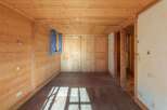 Step into this inviting space, featuring warm wooden walls and flooring that create a cozy atmosphere.